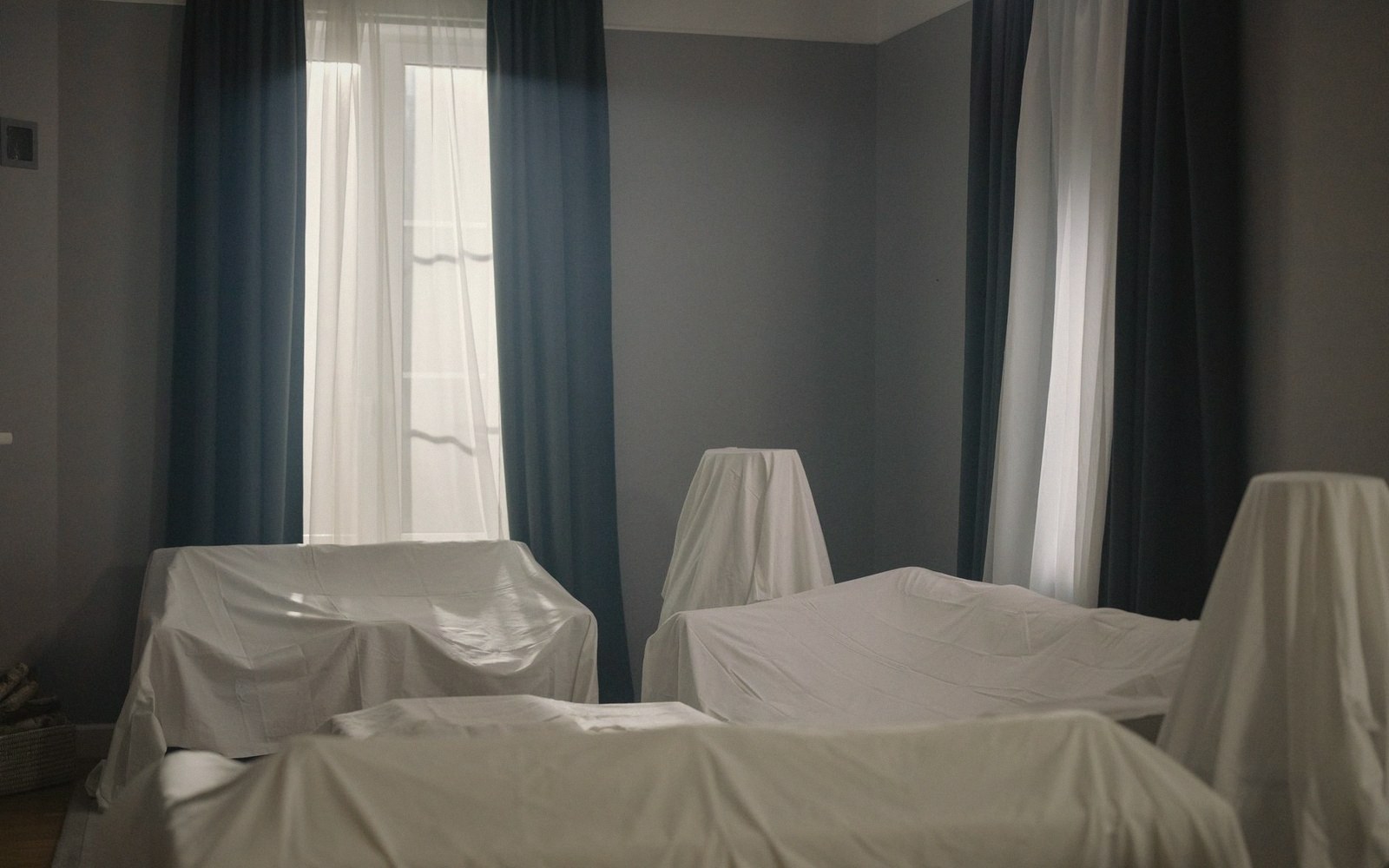 Dust sheets over furniture in a stripped room
